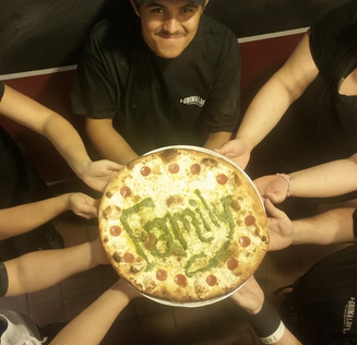 Team Members holding a pizza